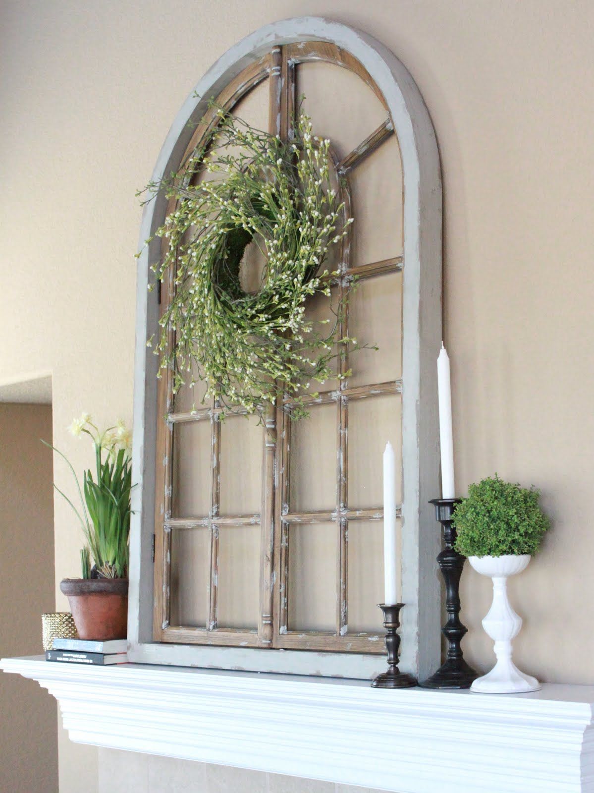 Fireplace mantel decor with an arched window frame