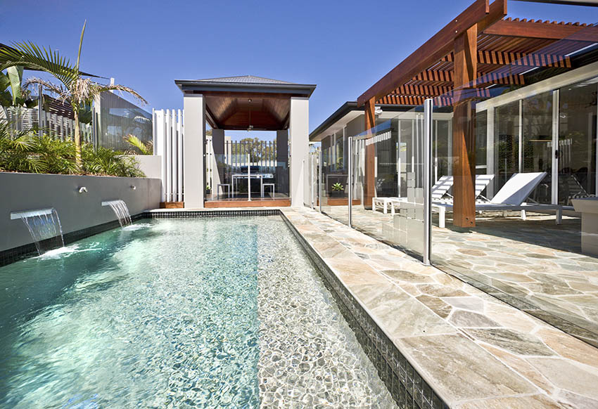 Flagstone pool patio with pergola and water features