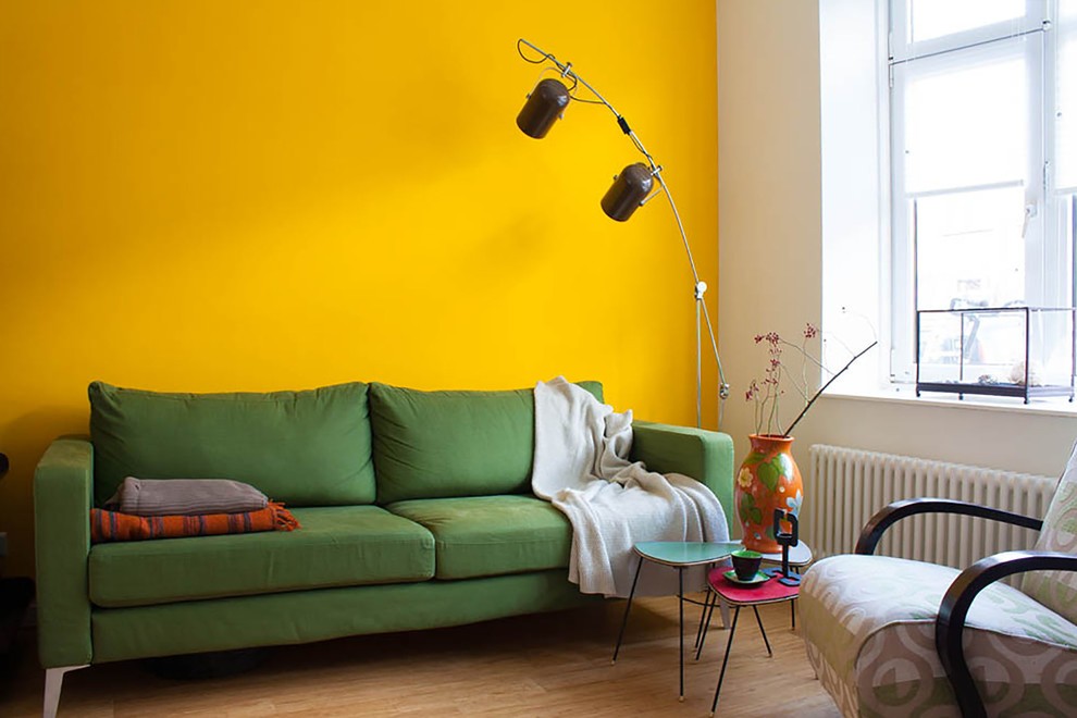 Зеленый диван около желтой стены