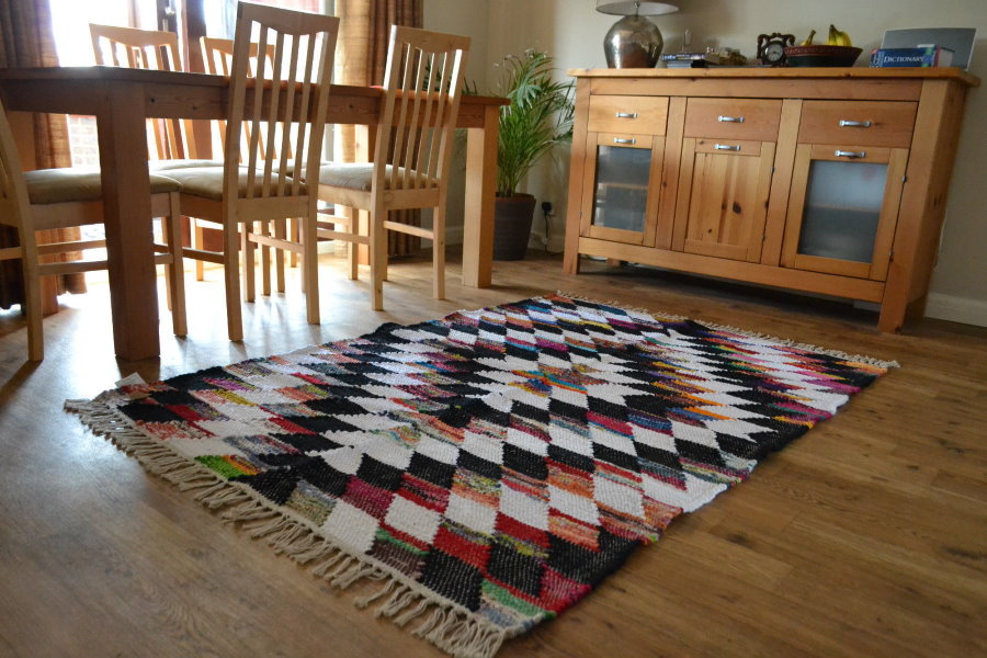 Пестрая окраска коврика на деревянном полу