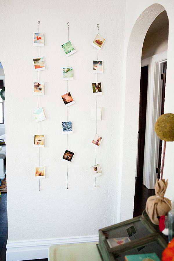 фотографии развешенные на верёвке на стене дома