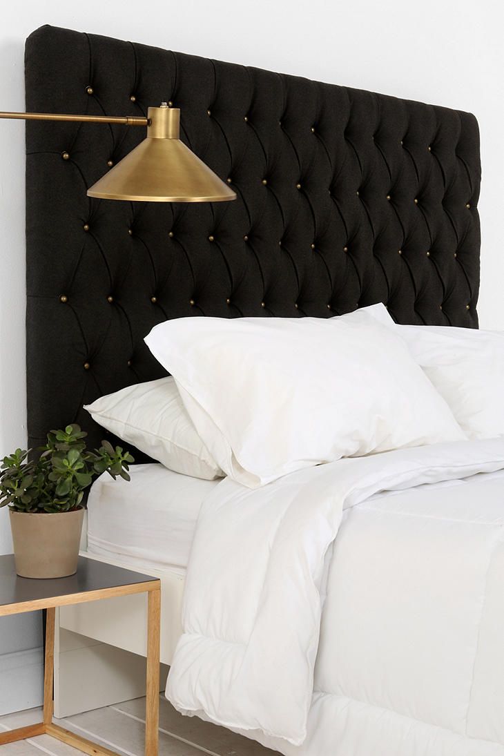 Изголовье кровати черного цвета в спальне