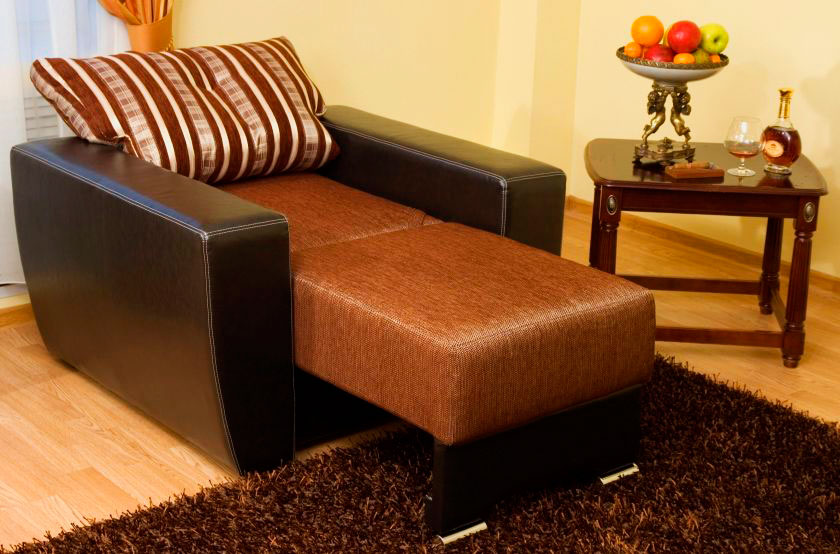 Раскладное кресло-кровать с подлокотниками в интерьере комнаты
