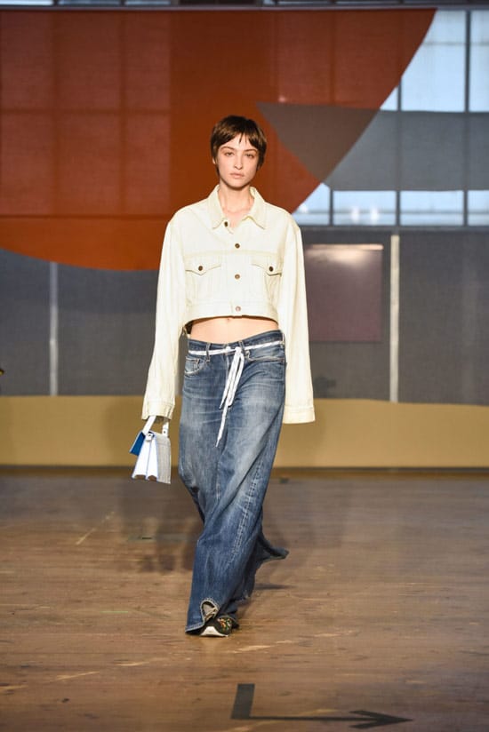 Модель в широких джинсах и сетлая куртка от Ganni