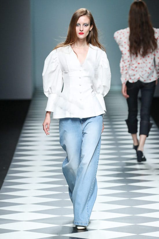 Модель в широких голубых джинсах и белая блузка от Kiok