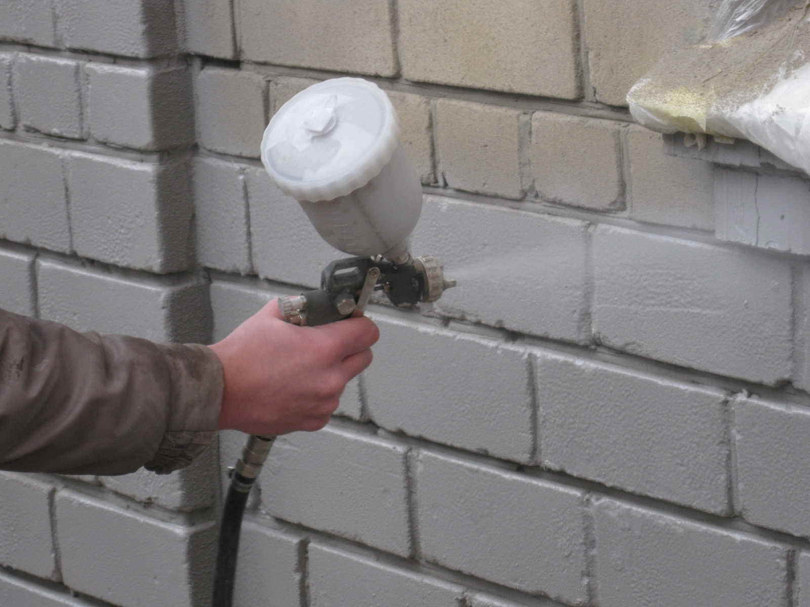 Нанесение жидкого утеплителя на стену