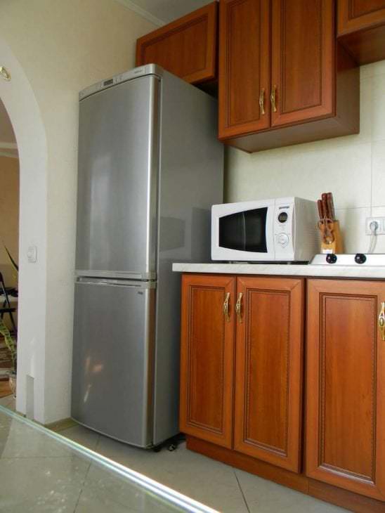 большой холодильник в дизайне кухни в черном цвете